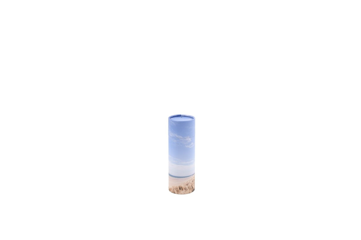 Small cylindrical pet ashes scattering tube with a beach scene image.